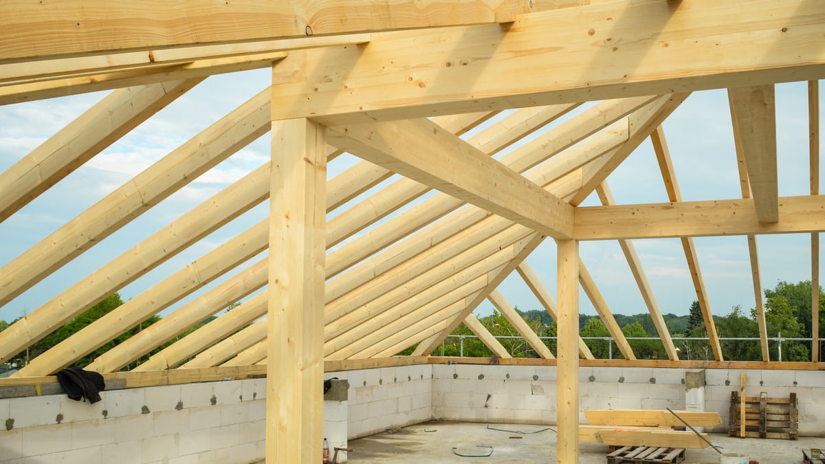 Wooden trusses structure in an unfinished building highlighting construction progress.